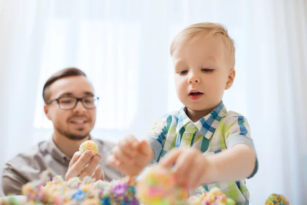 Father and son playing with ball clay at home — Stock Photo, Image