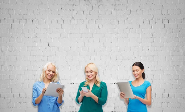 Mulheres felizes com smartphone e tablet pc computador — Fotografia de Stock