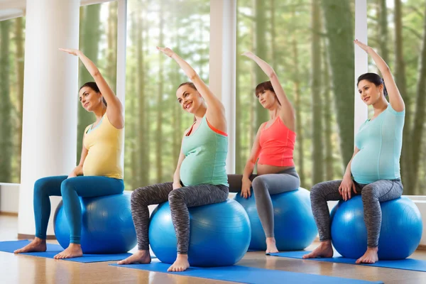 Mulheres grávidas felizes exercitando no fitball no ginásio — Fotografia de Stock