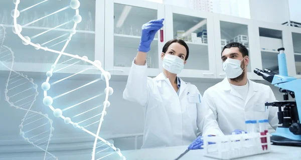 Jóvenes científicos haciendo pruebas o investigaciones en laboratorio — Foto de Stock