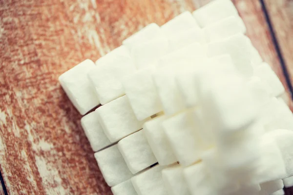 Κοντινό πλάνο της πυραμίδας της λευκής ζάχαρης στο ξύλινο τραπέζι — Φωτογραφία Αρχείου