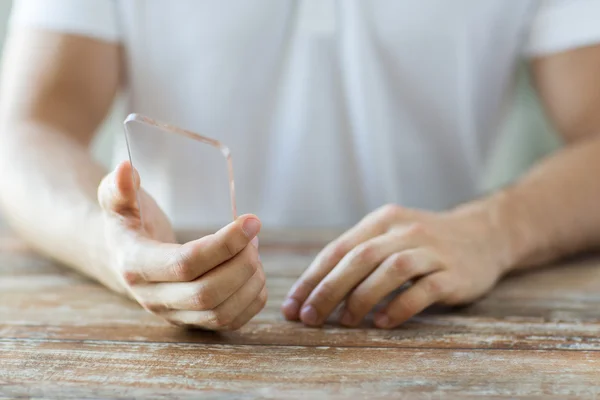 Close up of male hand with transparent smartphone — Stock Photo, Image