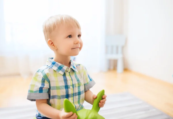 Fröhlicher kleiner Junge spielt zu Hause mit Aufsitzspielzeug — Stockfoto