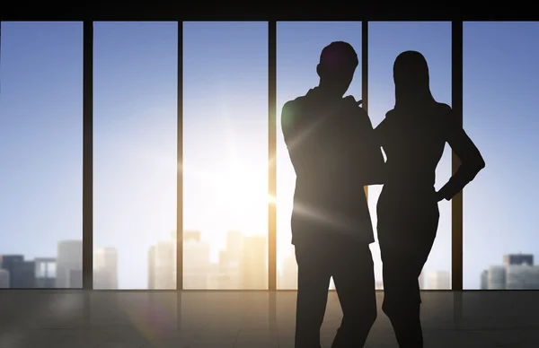 Silhouettes of business partners over office — Stock Photo, Image