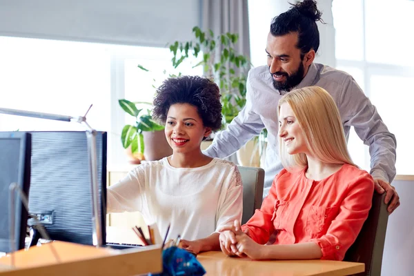 Lykkelig kreativ gruppe med datamaskin i embetet – stockfoto