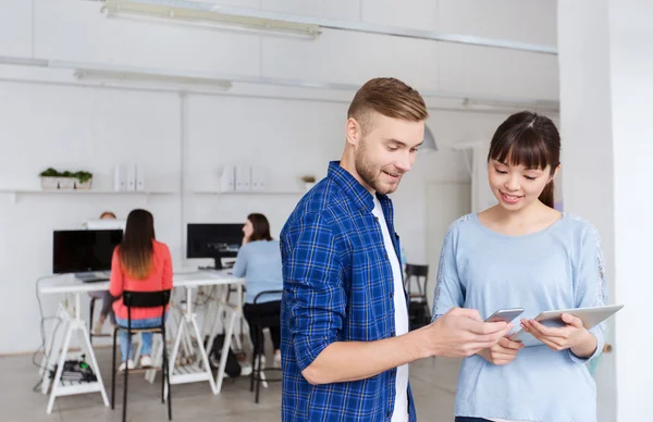 Couple avec smartphone et tablette PC au bureau — Photo