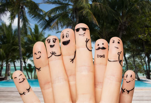 Close up of fingers with smiley faces on beach — Stock Photo, Image