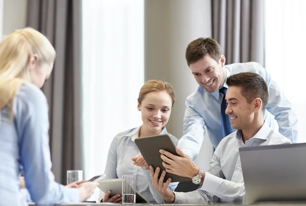 Pessoas de negócios sorridentes com tablet pc no escritório — Fotografia de Stock
