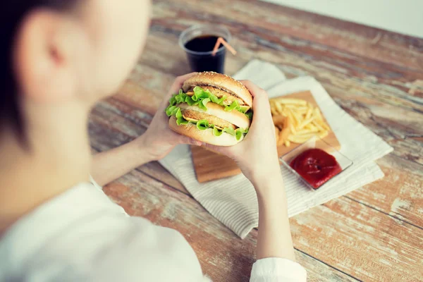 Zamknij się z kobieta ręce trzymając hamburger — Zdjęcie stockowe