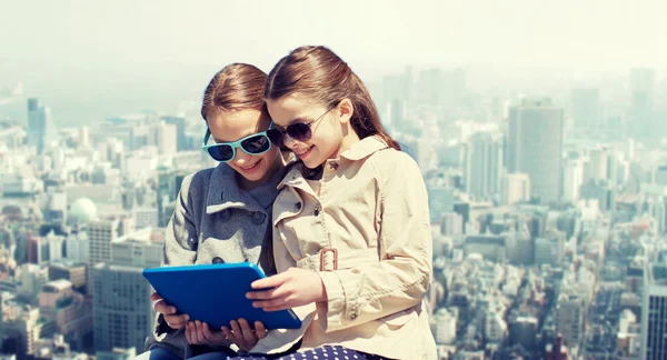 Meninas felizes com computador tablet pc sobre a cidade — Fotografia de Stock