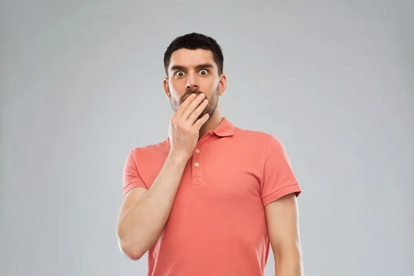 Homem assustado em polo t-shirt sobre fundo cinza — Fotografia de Stock