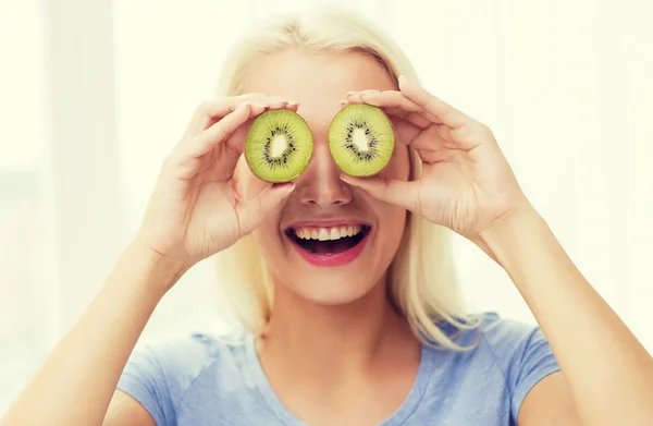 Mujer feliz que se divierte cubriendo los ojos con kiwi — Foto de Stock