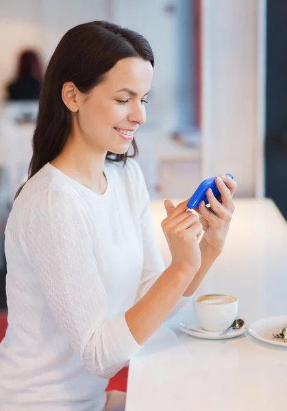 Donna sorridente con smartphone e caffè al caffè — Foto Stock