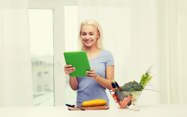 S úsměvem mladá žena s tablet pc vaření doma — Stock fotografie
