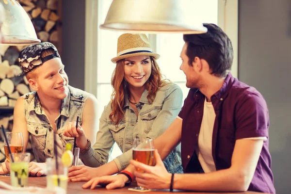 Amigos felices bebiendo cerveza y cócteles en el bar — Foto de Stock