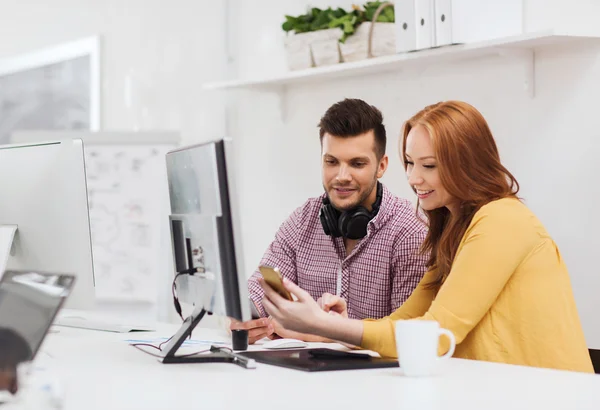 Tim kreatif tersenyum dengan smartphone di kantor — Stok Foto