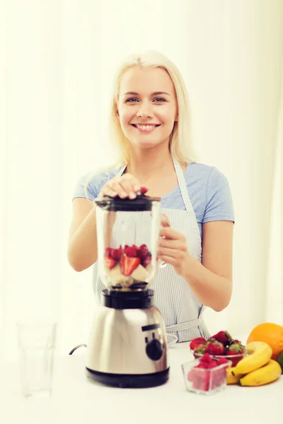 Mujer sonriente con licuadora preparando batido en casa —  Fotos de Stock