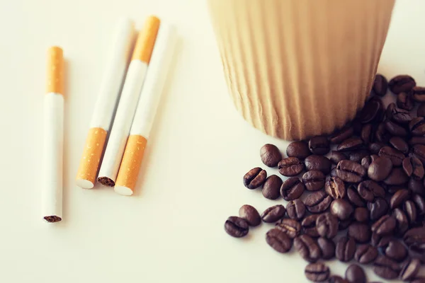 Close up of cigarettes, coffee cup and beans — Stock Photo, Image