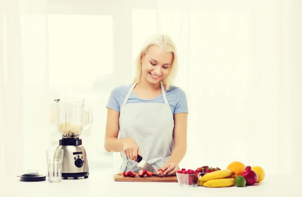 Leende kvinna med blender förbereder skaka hemma — Stockfoto