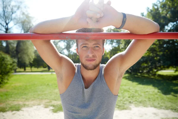 Young man exercising on horizontal bar outdoors — Stock Photo, Image