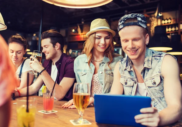 Amigos felizes com tablet pc e bebidas no bar — Fotografia de Stock