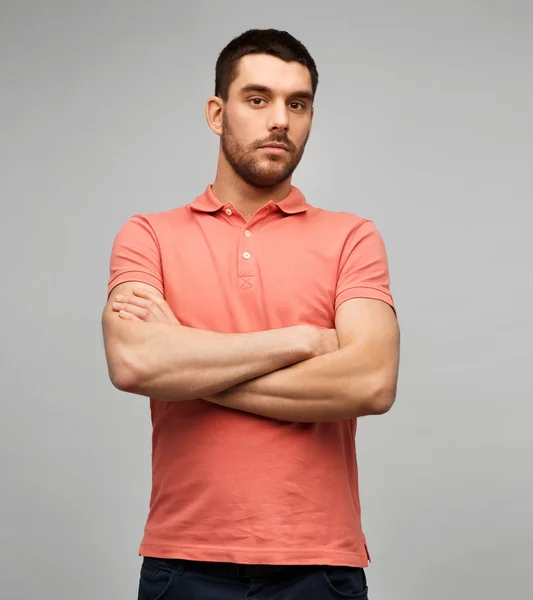 Jeune homme avec les bras croisés sur fond gris — Photo