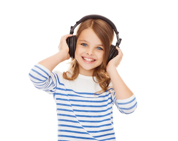 Menina sorridente com fones de ouvido ouvindo música — Fotografia de Stock