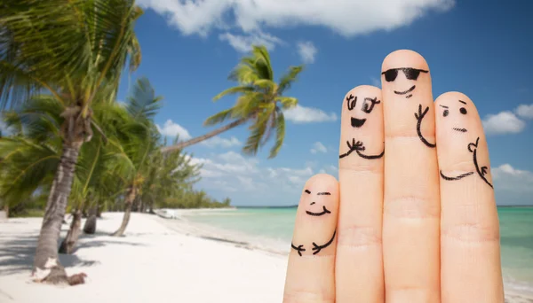 Gros plan des doigts avec des visages souriants sur la plage — Photo