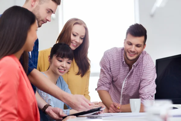 Gelukkig creatieve team met tablet pc op kantoor — Stockfoto