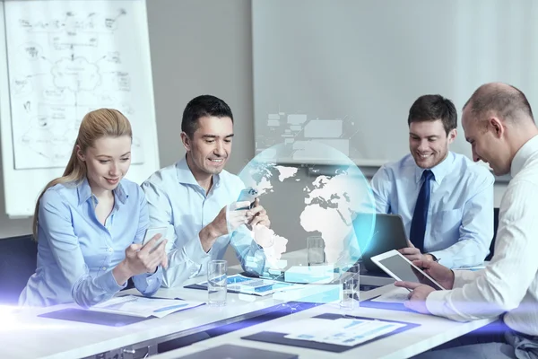 Glimlachende mensen uit het bedrijfsleven met gadgets in office — Stockfoto