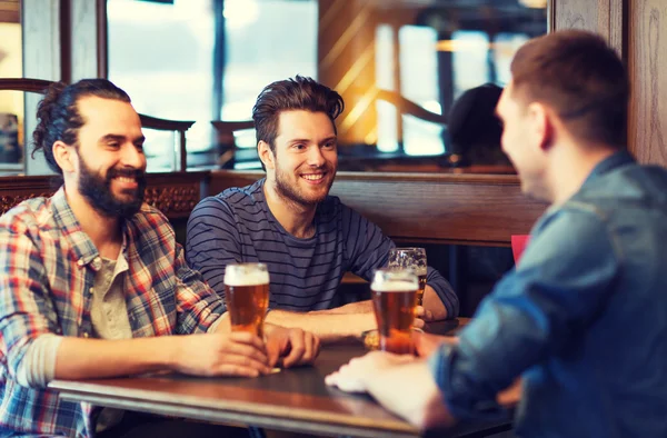 Щасливі чоловіки друзі п'ють пиво в барі або пабі — стокове фото
