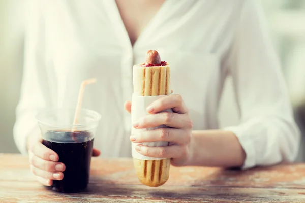 Primer plano de la mujer con hot dog y bebida de coca — Foto de Stock