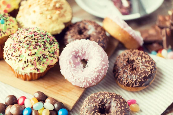 Close up of glazed donuts and sweets on table — Stock Fotó