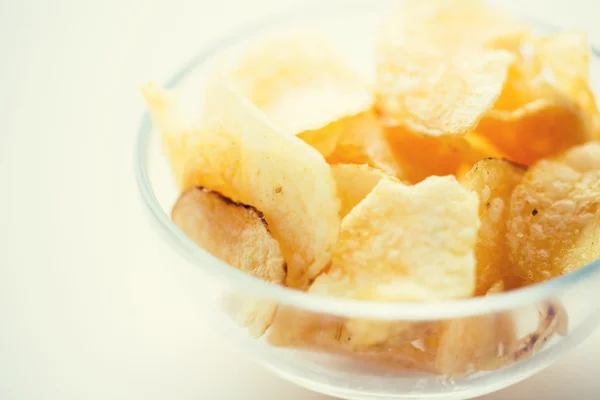 Close up of crunchy potato crisps in glass bowl — Stock Photo, Image