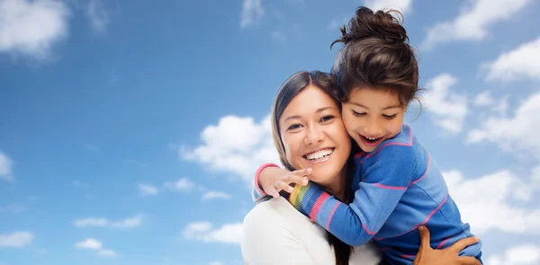 Hugging mother and daughter over sky background — Stock Photo, Image