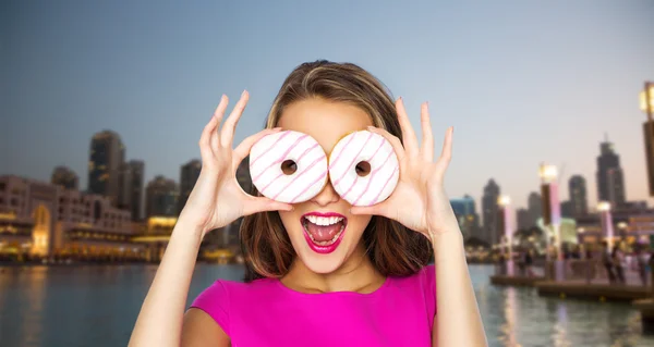 Mujer feliz o chica adolescente mirando a través de donuts —  Fotos de Stock