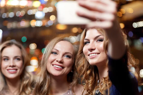 Women with smartphone taking selfie at night club — Stock Photo, Image