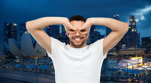 Man maken van vinger glazen over stad achtergrond — Stockfoto