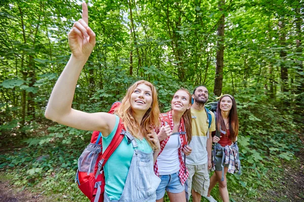 Groep lachende vrienden met rugzakken wandelen — Stockfoto