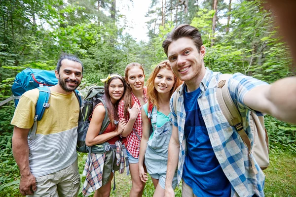 Vänner med ryggsäcken ta selfie i trä — Stockfoto