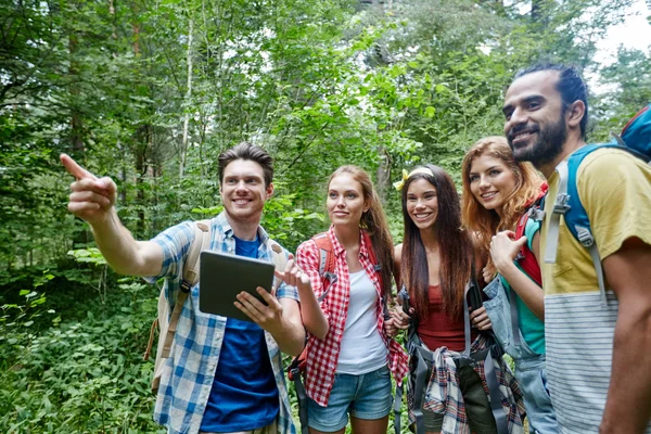 Amici felici con zaini e tablet pc trekking — Foto Stock