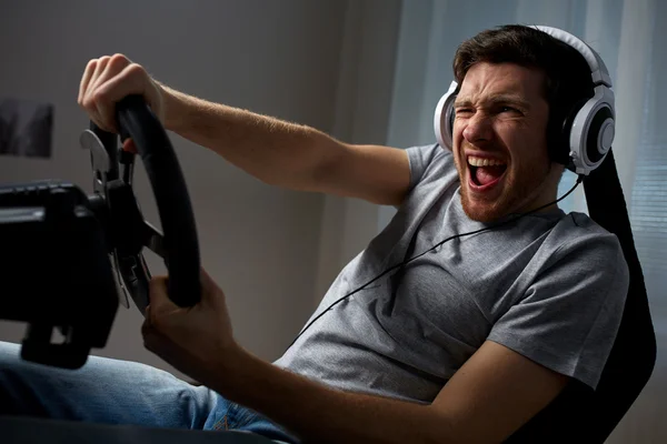 Man playing car racing video game at home — Stock Photo, Image