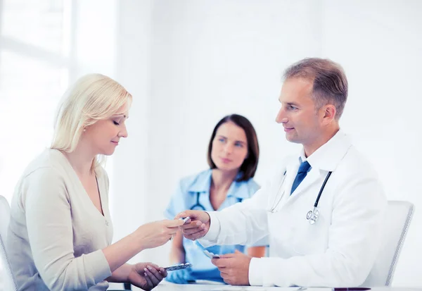 Doctor giving tablets to patient in hospital — Stock Photo, Image