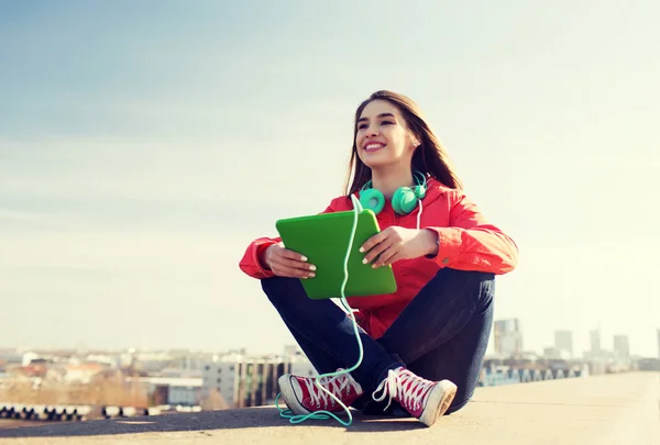 Gelukkig jonge vrouw met tablet pc en hoofdtelefoon — Stockfoto