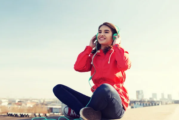 Gelukkig jonge vrouw in koptelefoon luisteren naar muziek — Stockfoto