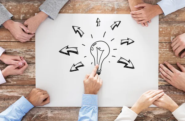Primo piano del team aziendale che punta a bulb doodle — Foto Stock
