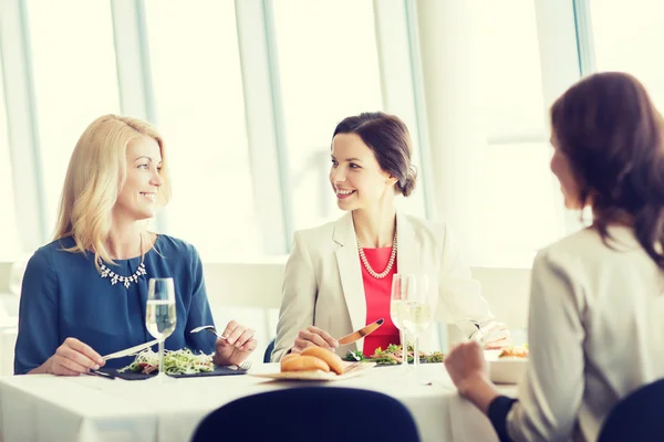 Gelukkig vrouwen eten en praten in restaurant — Stockfoto