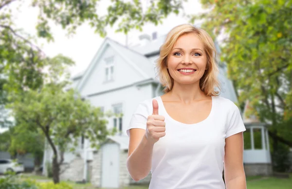 Lachende vrouw in wit t-shirt weergegeven: duimen omhoog — Stockfoto