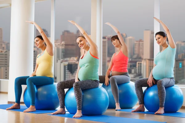 Mujeres embarazadas felices haciendo ejercicio en fitball en el gimnasio —  Fotos de Stock