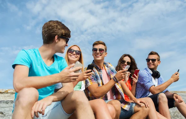 Group of happy friends with smartphones outdoors — Stok fotoğraf